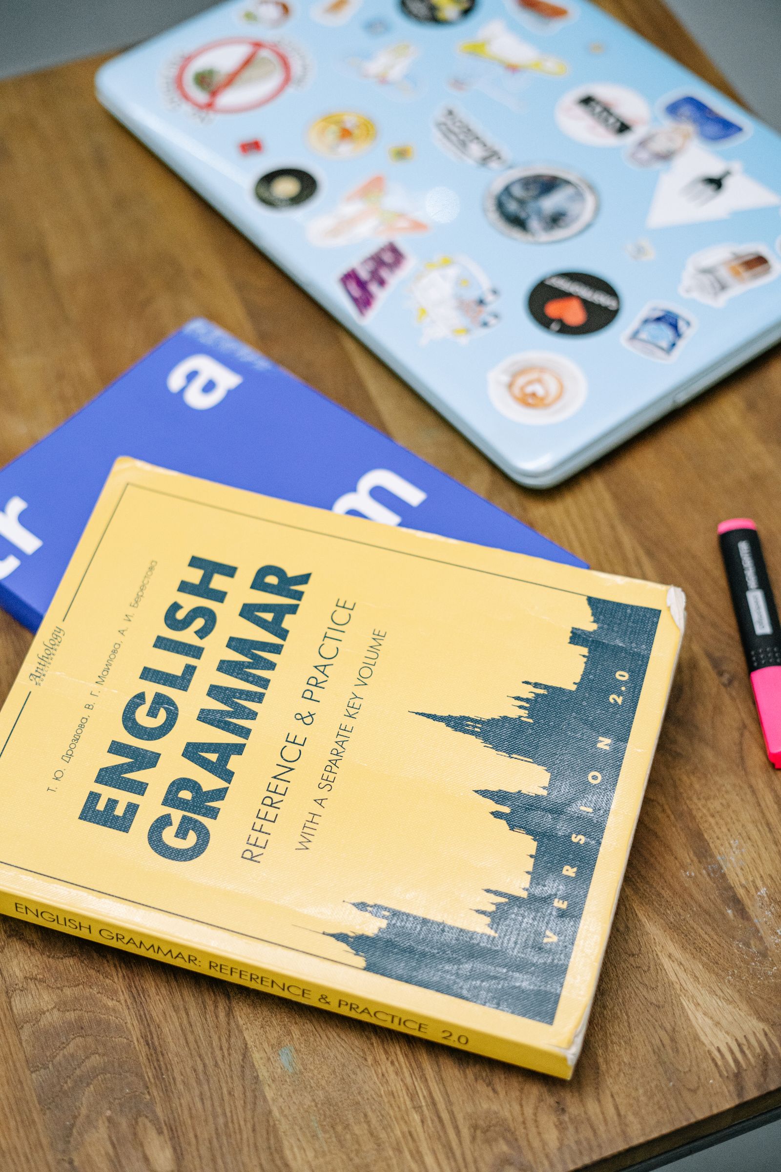 Language learning books beside a laptop